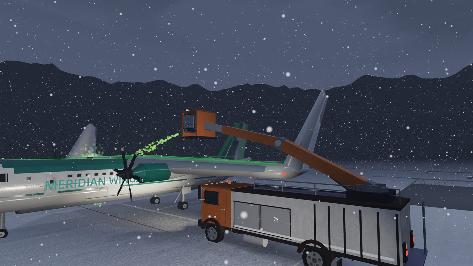 A boom de-icer spraying green anti-ice fluid onto a wing while snow falls at night.