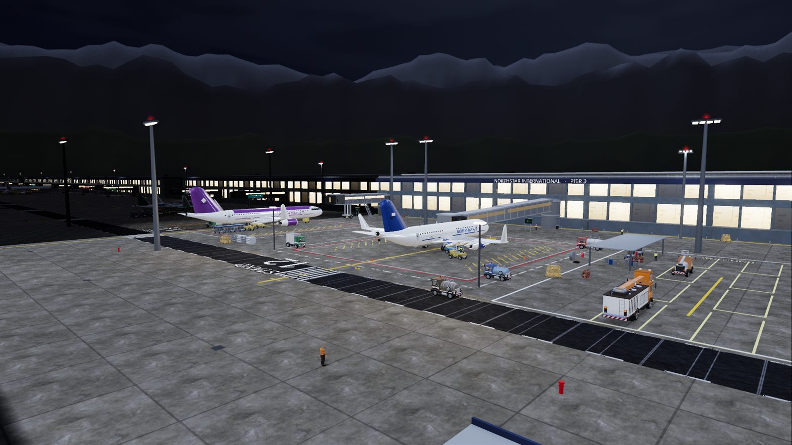The apron at night from above: several stands worked at once under floodlights, aircraft at the pier.